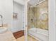 Bright bathroom featuring marble tile, glass shower door, and a separate towel rack at 5128 W Longfellow Ave, Tampa, FL 33629