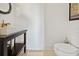 Modern powder room with a unique sink, gold faucet, and neutral-toned walls with tile flooring at 5128 W Longfellow Ave, Tampa, FL 33629