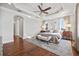 Spacious bedroom with hardwood floors, ceiling fan, tray ceiling, and natural light at 5128 W Longfellow Ave, Tampa, FL 33629