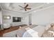 Bright bedroom featuring a ceiling fan, hardwood floors, and tray ceiling at 5128 W Longfellow Ave, Tampa, FL 33629