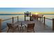 Relaxing waterfront view from dock with chairs, table, and wine glasses at sunset at 5128 W Longfellow Ave, Tampa, FL 33629