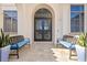 Elegant front entrance with decorative doors, benches, and planters on a light tile surface at 5128 W Longfellow Ave, Tampa, FL 33629