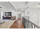 Open-concept hallway with hardwood floors leads to staircase and living area with a large television at 5128 W Longfellow Ave, Tampa, FL 33629
