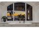 Kitchen sink with white countertops offers beautiful sunset views through a large arched window at 5128 W Longfellow Ave, Tampa, FL 33629