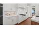 Bright white kitchen with stainless steel gas range, hood, and marble backsplash at 5128 W Longfellow Ave, Tampa, FL 33629