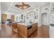 Open-concept kitchen with kitchen islands featuring wood cabinets, white countertops, and brick flooring at 5128 W Longfellow Ave, Tampa, FL 33629