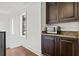 Convenient kitchenette with dark cabinets, a microwave, granite countertops, and natural light at 5128 W Longfellow Ave, Tampa, FL 33629