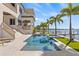 Luxury waterfront home featuring a beautiful pool with spa and lush landscaping with dock on the water at 5128 W Longfellow Ave, Tampa, FL 33629