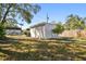 View of the backyard and detached garage with a privacy fence and mature trees at 6202 Tennessee Ave, New Port Richey, FL 34653