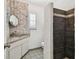 Neutral bathroom with mosaic tile wall, hanging mirror, and a walk-in shower with dark tile at 6202 Tennessee Ave, New Port Richey, FL 34653