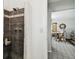 Walk-in shower with dark tile, with a partial view of an adjacent dining area at 6202 Tennessee Ave, New Port Richey, FL 34653