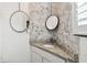 Elegant bathroom featuring granite countertops, decorative tile, and round, hanging mirrors at 6202 Tennessee Ave, New Port Richey, FL 34653