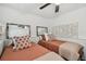 Charming bedroom with two twin beds, decorative mirrors, and a ceiling fan at 6202 Tennessee Ave, New Port Richey, FL 34653