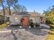 Inviting home featuring a gravel yard, coral door, and well-maintained landscaping at 6202 Tennessee Ave, New Port Richey, FL 34653