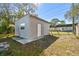 View of the detached garage with a door and a window on a sunny day at 6202 Tennessee Ave, New Port Richey, FL 34653