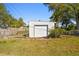 View of the detached garage with a garage door and partially fenced in backyard at 6202 Tennessee Ave, New Port Richey, FL 34653