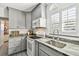 Gray kitchen with granite countertops, white appliances, subway tile backsplash, and a stainless steel sink at 6202 Tennessee Ave, New Port Richey, FL 34653