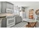 Well-equipped kitchen with gray cabinetry, stainless steel appliances, and adjacent dining area at 6202 Tennessee Ave, New Port Richey, FL 34653