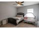 Bedroom with dark furniture and light gray walls, ceiling fan and adjacent crib at 6615 S Manhattan Ave # 2, Tampa, FL 33616