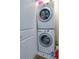 Stacked washer and dryer in laundry room with tiled flooring and white cabinets at 6615 S Manhattan Ave # 2, Tampa, FL 33616