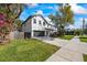 A modern two-story home showcasing a well-kept lawn and a long driveway at 6808 S Sparkman St, Tampa, FL 33616