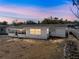 View of the back of the house in the evening featuring a screened-in patio at 7305 Windsor St, Hudson, FL 34667