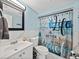 Nicely decorated bathroom with vanity and beach-themed shower curtain at 7305 Windsor St, Hudson, FL 34667