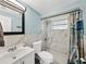 Bathroom featuring a toilet, sink, and shower with beach-themed shower curtain at 7305 Windsor St, Hudson, FL 34667