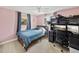 Cozy bedroom with a bed, desk with computer monitors, and pink walls at 7305 Windsor St, Hudson, FL 34667