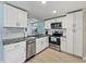 Modern kitchen boasts stainless steel appliances, white cabinets, and granite countertops at 7305 Windsor St, Hudson, FL 34667