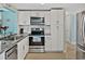 Modern kitchen with stainless steel appliances, granite countertops, and white cabinetry at 7305 Windsor St, Hudson, FL 34667