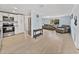 A cozy open living room with light wood flooring, open to the kitchen, and a sofa at 7305 Windsor St, Hudson, FL 34667