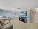 A cozy living room featuring light wood flooring, a sofa, and an entertainment area at 7305 Windsor St, Hudson, FL 34667