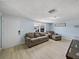 A cozy living room featuring light wood flooring, a sofa, and natural light at 7305 Windsor St, Hudson, FL 34667