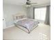 A comfortable bedroom featuring a ceiling fan, plush carpet, and neutral wall paint at 7771 Davie Ray Dr, Zephyrhills, FL 33540