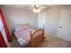 Cozy bedroom featuring a ceiling fan, neutral paint, and a comfortable bed with patterned bedding at 7771 Davie Ray Dr, Zephyrhills, FL 33540