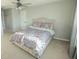 A comfortable bedroom featuring a ceiling fan, plush carpet, and neutral wall paint at 7771 Davie Ray Dr, Zephyrhills, FL 33540