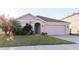Charming single-story home featuring a well-manicured lawn, a two car garage, and beautiful landscaping at 7771 Davie Ray Dr, Zephyrhills, FL 33540