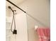 Close up of shower head with white tiled walls and corner shelving at 7771 Davie Ray Dr, Zephyrhills, FL 33540