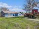 Expansive backyard features lush grass, mature trees, a slide, and a playhouse, ideal for outdoor activities and recreation at 7843 Shoupe Rd, Plant City, FL 33565
