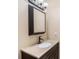 Neutral bathroom featuring a stone countertop, dark cabinets, and a framed mirror at 7843 Shoupe Rd, Plant City, FL 33565