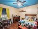 Comfortable bedroom with blue ceiling, a wooden desk, and a bed with patterned bedding at 7843 Shoupe Rd, Plant City, FL 33565