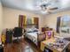 Bedroom furnished with a bed, desk, and wooden floors, offering space to study and rest at 7843 Shoupe Rd, Plant City, FL 33565