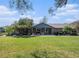 Charming stone home with covered patio, a well-manicured lawn, and a peaceful, inviting atmosphere at 7843 Shoupe Rd, Plant City, FL 33565