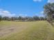 Expansive grassy land, fenced and framed by mature trees, offering potential for various outdoor activities at 7843 Shoupe Rd, Plant City, FL 33565