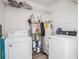 Practical laundry room equipped with washer, dryer, shelving, and a water heater, providing functionality and convenience at 7843 Shoupe Rd, Plant City, FL 33565