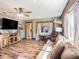 Comfortable living room features a sofa, leather chair, wood-look floors, and a large window at 7843 Shoupe Rd, Plant City, FL 33565