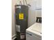 Close up of a Rheem Professional water heater with an energy guide, situated near a washing machine at 7843 Shoupe Rd, Plant City, FL 33565