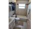 Well-lit bathroom with a shower-tub combination, white fixtures, tiled walls, and a decorative accent tile at 7966 Knox Loop, New Port Richey, FL 34655