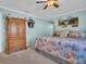 Bright bedroom featuring a decorative bedspread, wood armoire, and beach-themed wall art at 811 Helmsman Way, Palm Harbor, FL 34685
